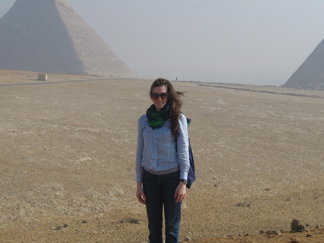A photo of Dr. LIsa Haney in front of some Egyptian pyramids