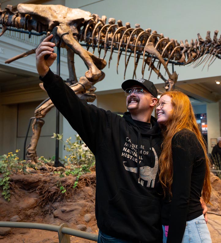 A couple taking a selfie in front of a Trex