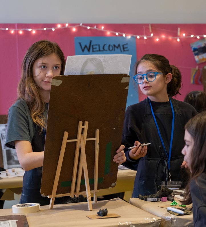 two girls looking at an easel