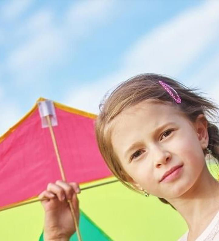 A young girl holding a colorful kite