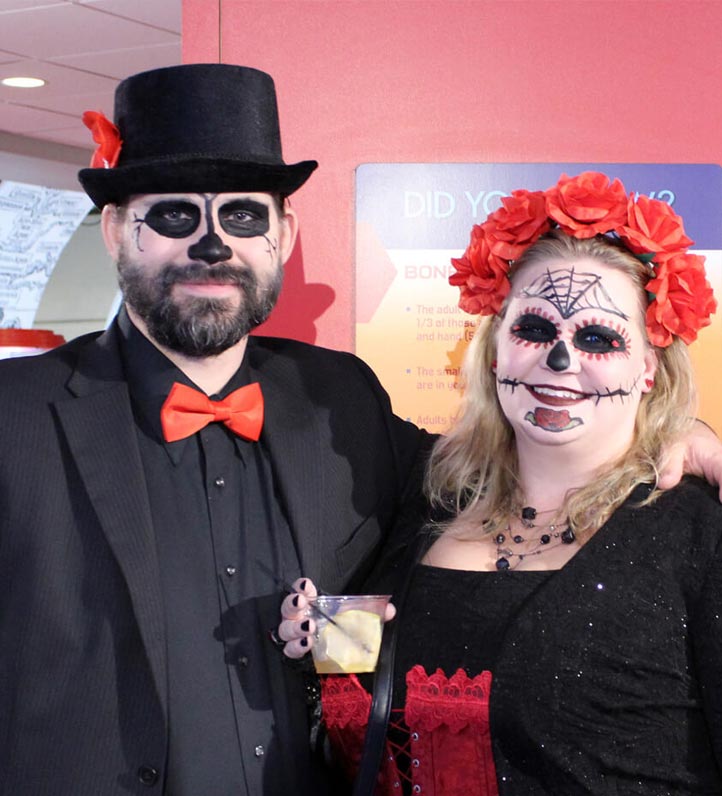 A couple in halloween costumes posing for a photo