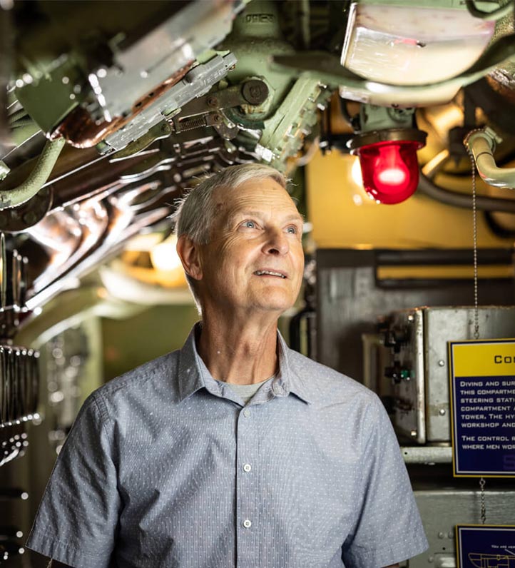 an older man inside a submarine, looking around