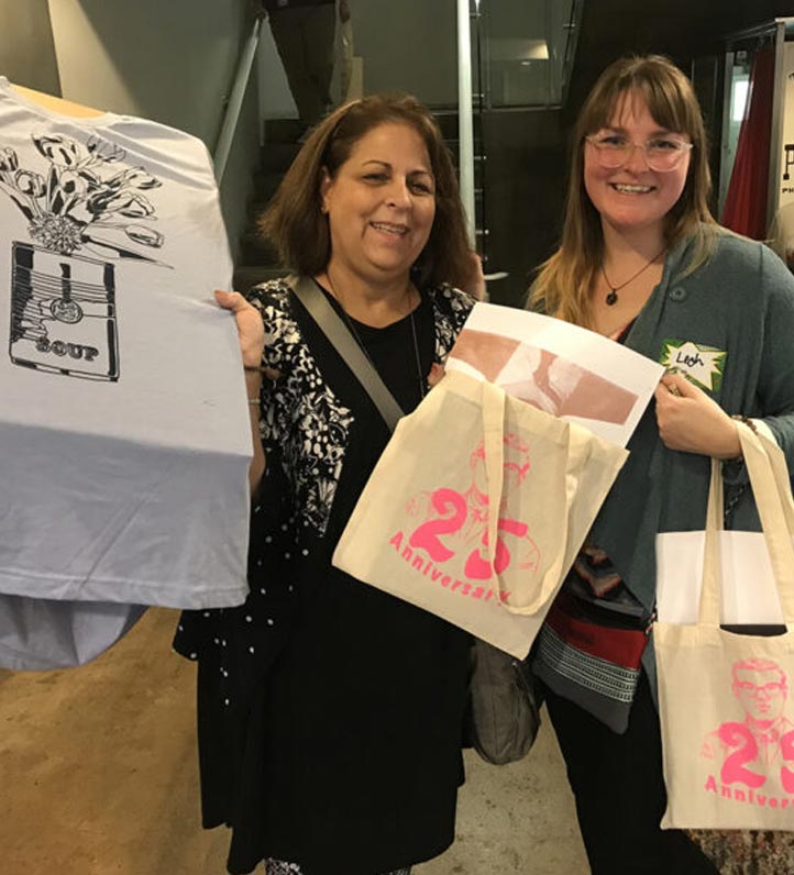 two teachers showing silkscreen t-shirt and bags