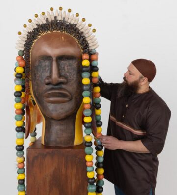 Sharif Bey with a larger than life bust carved in wood with a beaded headdress