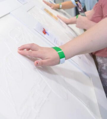 a hand touching a tactile artwork