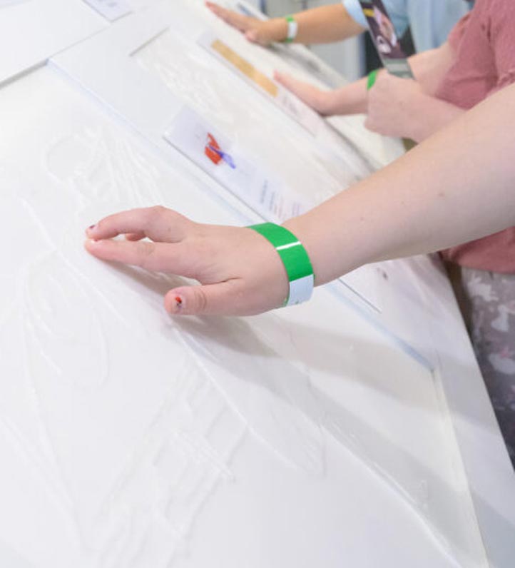 a hand touching a tactile artwork