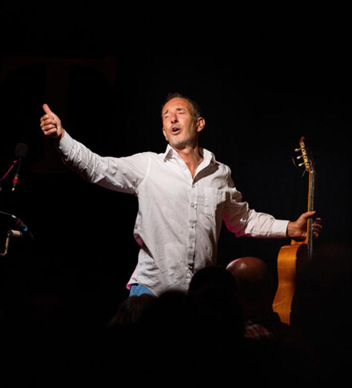 Photo of Jonathan Richman holding a guitar and singing