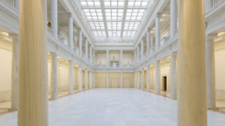 Spacious, elegant interior of a marble hall featuring tall columns and a skylight, creating a bright, open ambiance.