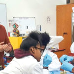 Andre Samuel leading a clas of young science students.