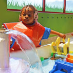 A young child playing in the water at carnegie science center