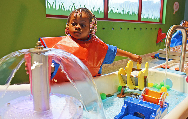 A young child playing in the water at carnegie science center