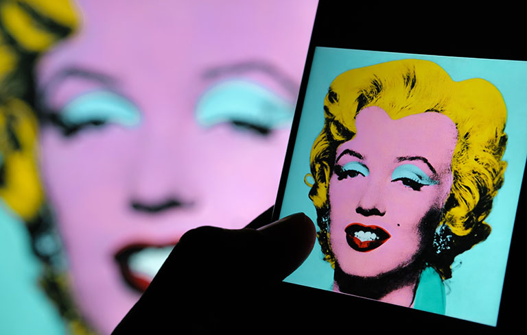 a mobile phone with an image of Warhol's painting of Marilyn Monroe