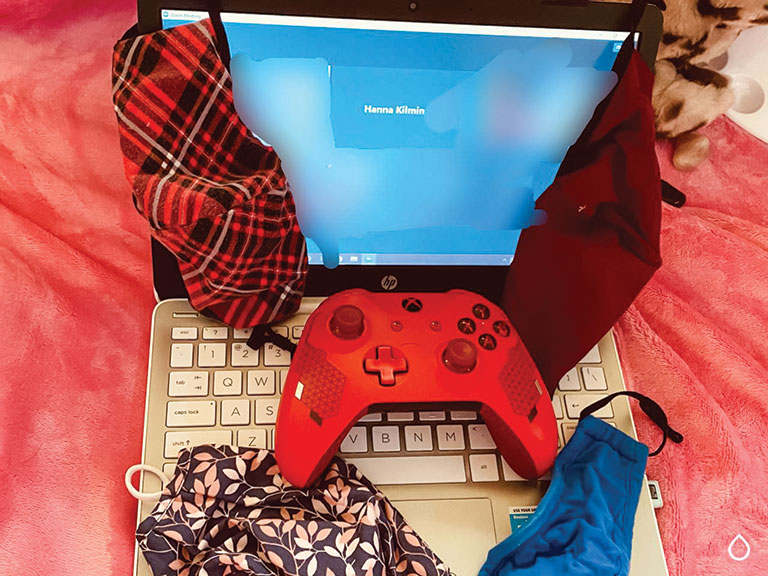 a laptop with an xbox controller and a mask
