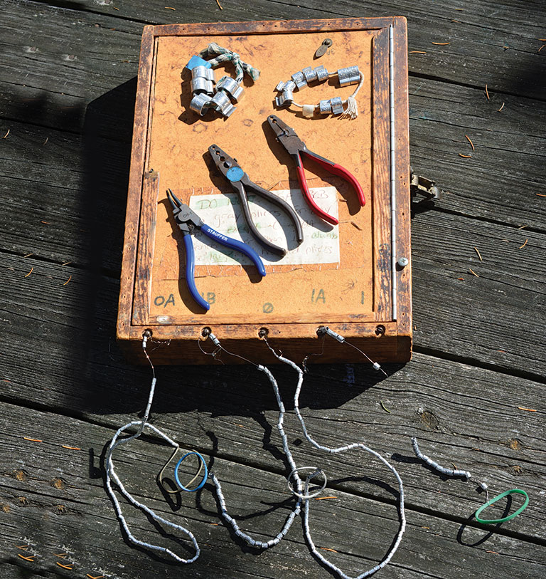 A hand-made banding box with bands and tools set out on top of it.