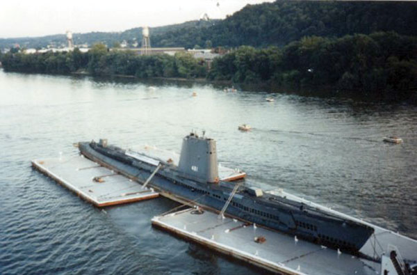 A submarine being towed in a  river