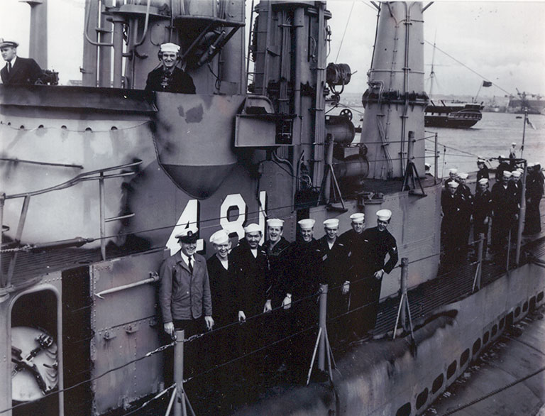 A vintage photo of the crew of a submarine posing on it's deck