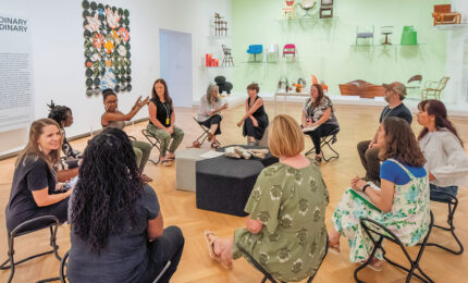 A group of teachers sitting in a circle, talking and laughing.