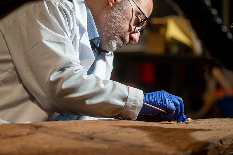 A conservator working on an ancient egyptian artifact.