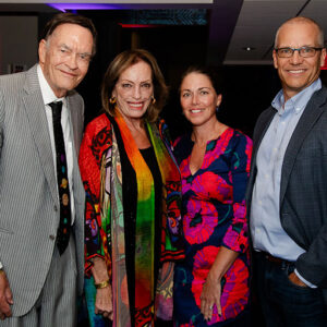 A group of four people posing for a photo at an event.