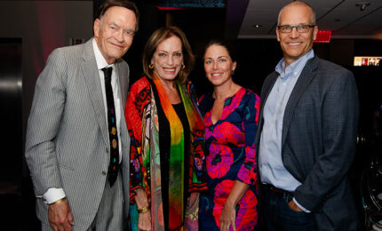 A group of four people posing for a photo at an event.