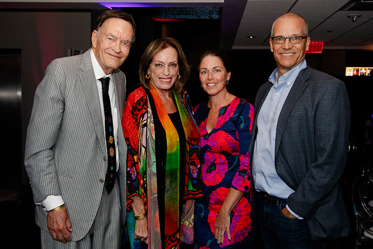 A group of four people posing for a photo at an event.