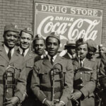 A group of uniformed military band members pose smiling with instruments under vintage Coca-Cola and drugstore signs. The mood is cheerful and proud.