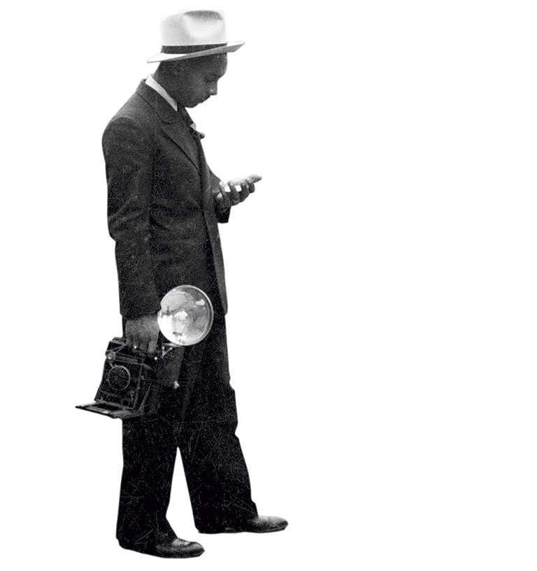 black and white image of a man holding an old-timed camera