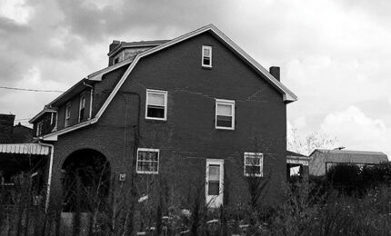 A black and white photo of an abandoned home