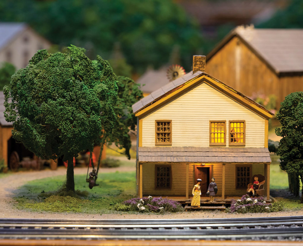Miniature version of home with figures on the front porch