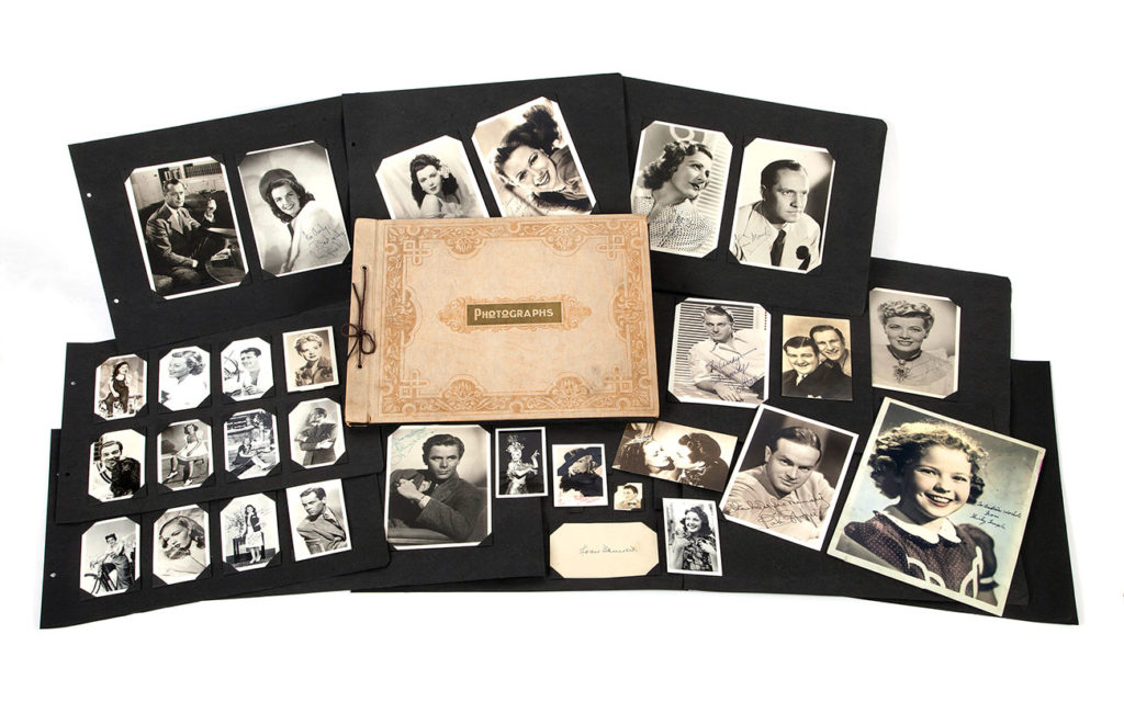 A group of scrapbooks opened up showing black and white photos of celebrities