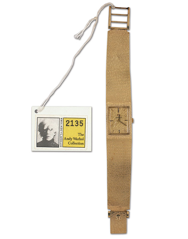 A gold watch with a Warhol store tag.