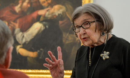 An art docent givinga tour to an elderly museum visitor