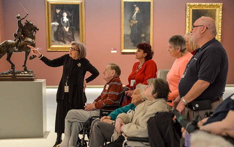 An art docent givinga tour to a group of elderly museum visitors