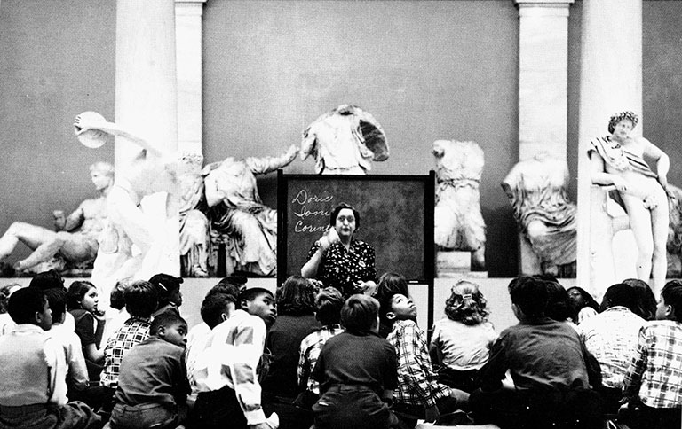 A vintage black and white photo of students in the art museum classes