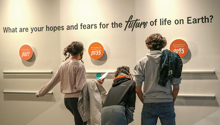 A group of teens looking at an exhibit about nature