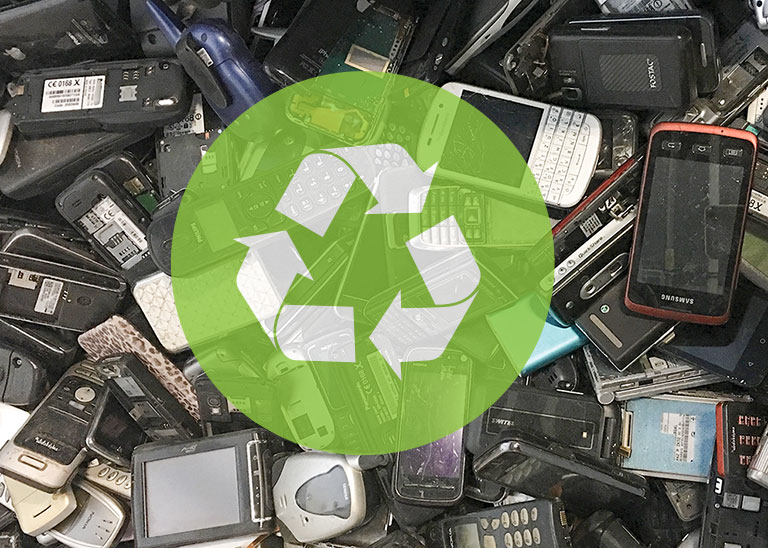 a recycle symbol transposed over a pile of broken cellphones