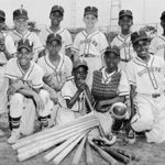 A black and white photo group of youg boys posing in their baseball uniforms