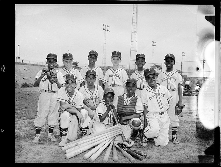 A black and white photo group of youg boys posing in their baseball uniforms