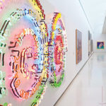 An gallery installation view of a colorful neon artwork