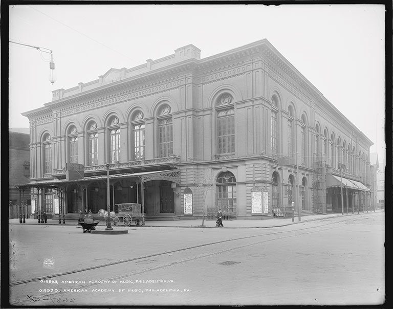 A historic photo of a large music hall building.