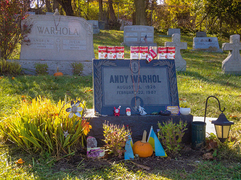 A cemetery with headstones containing names of Andy Warhol and another with the name Warhola.
