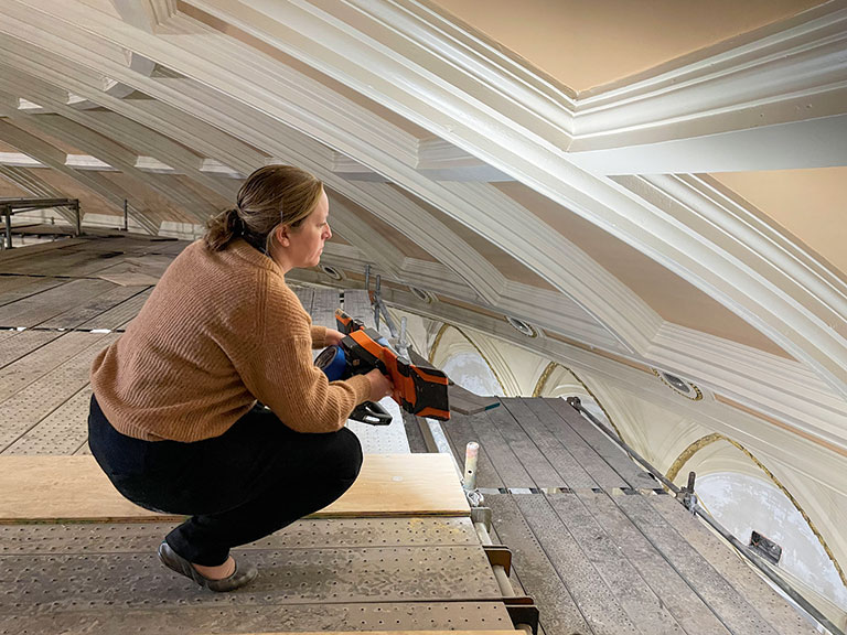 A female product manager observes renovation work on a music hall.