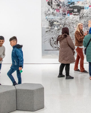 An art museum educator leading a tour of immigrant families through the museum.