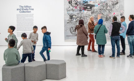 An art museum educator leading a tour of immigrant families through the museum.