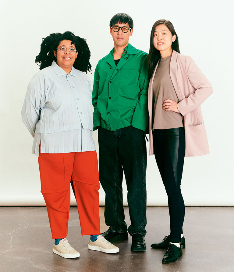 Three curators dressed in brightly colored clothing.