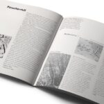 An open magazine features two pages with black-and-white photographs and text. The left page shows snow-covered branches, while the right has varied nature images. The tone is reflective.