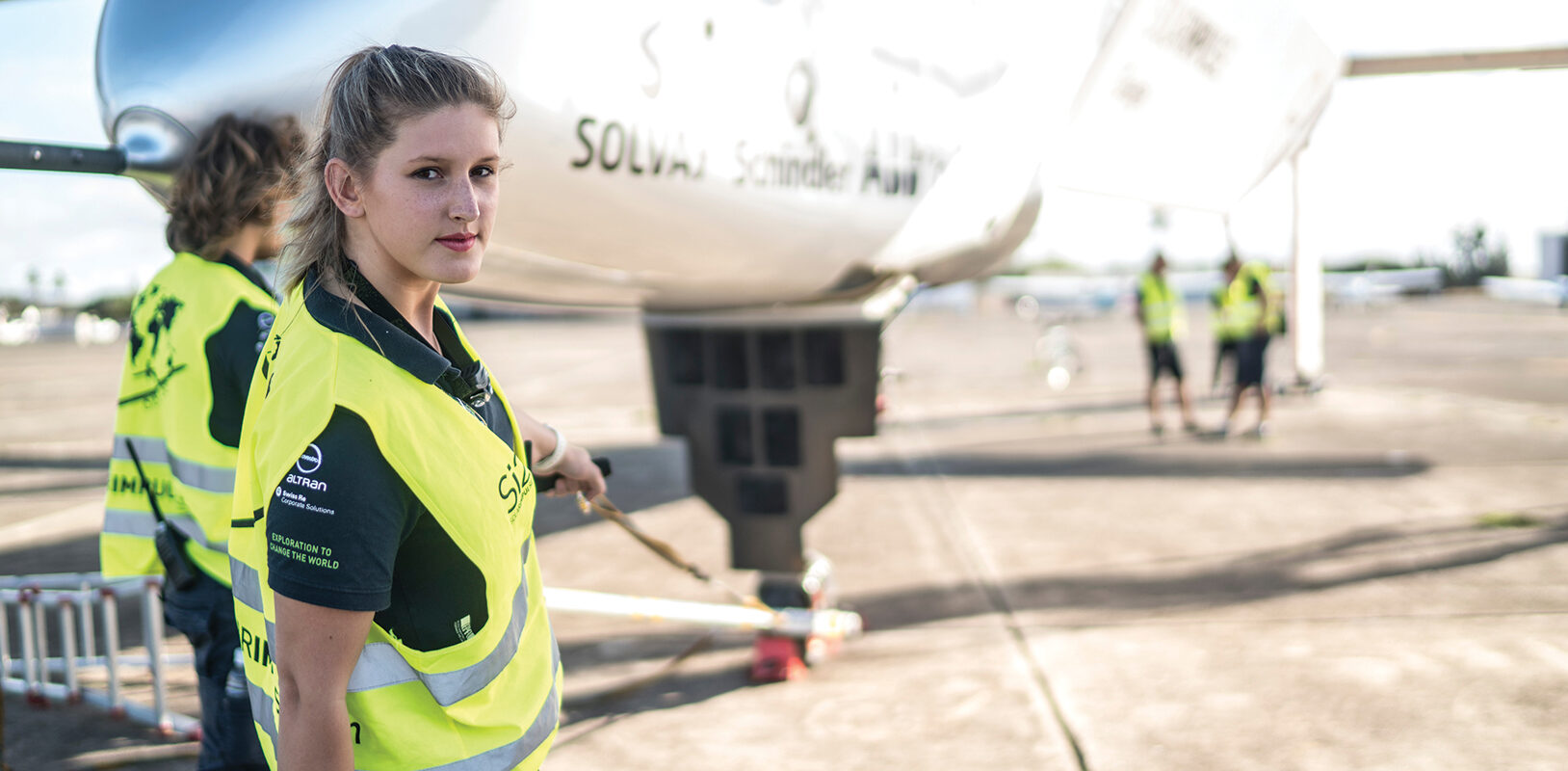 Young female electrical engineer working on teh ground crew of a solar powered plane