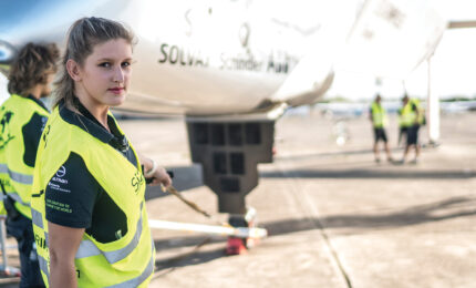Young female electrical engineer working on teh ground crew of a solar powered plane