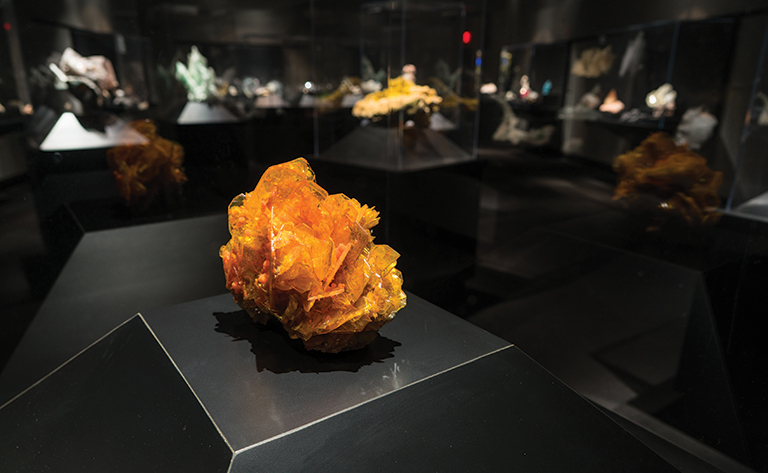 Bright orange gem in a case in the Hillman Hall of Minerals and Gems