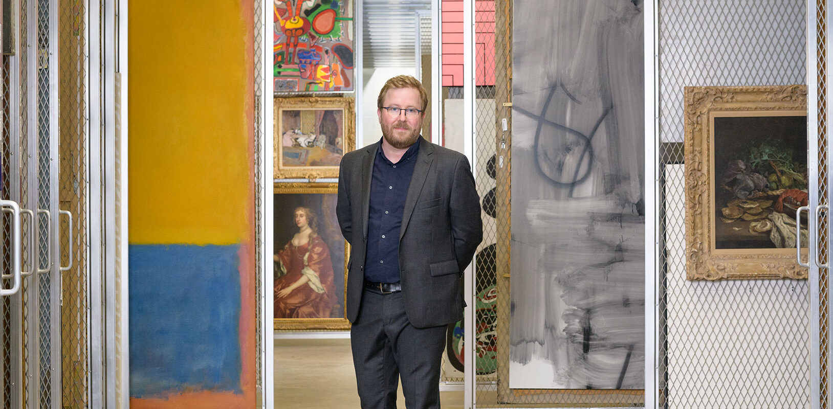 Portrait of Eric Crosby standing in the painting storage area of Carnegie Museum of Art